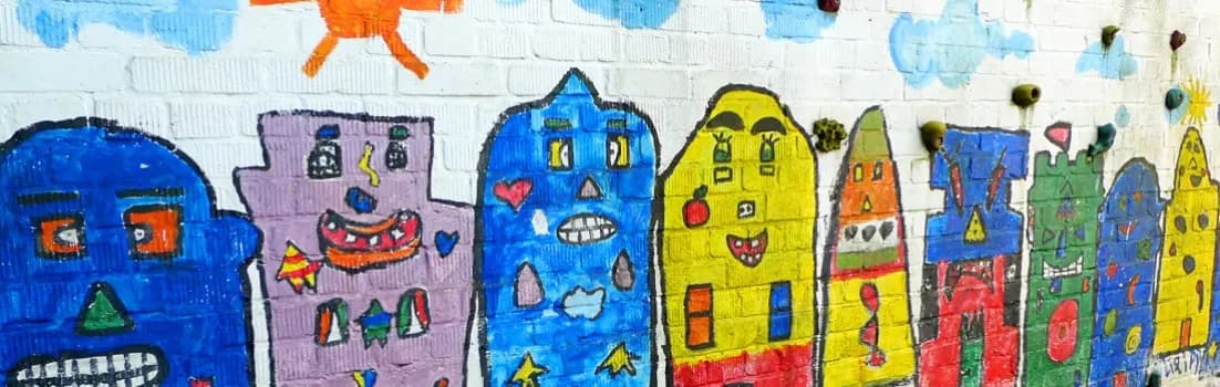 Von Kindern gemaltes Wandbild mit bunten, fröhlichen Häusern